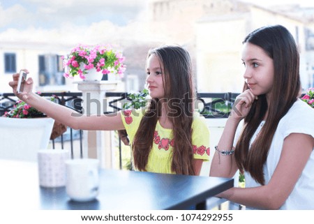 Two girls have fun and make selfie with the smartphone