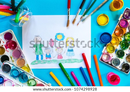 Children drawing pencil happy family mom, dad, son, daughter sunny day on the lawn and paint accessories, brush, felters gouache, watercolor on a blue background flat lay top view from above