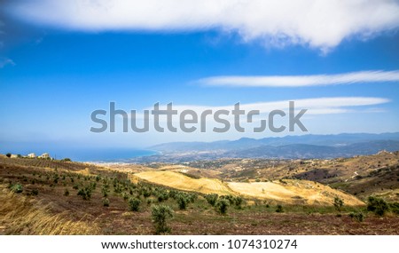 Green meadow in mountainous terrain and the blue sky with clouds