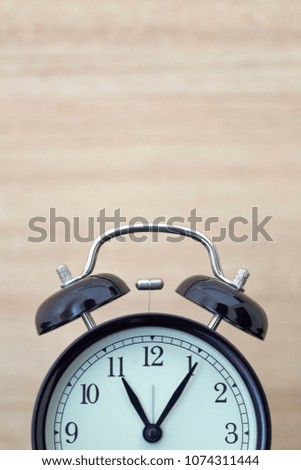 Black retro alarm clock on wood table, concept time change spring