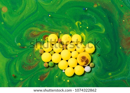 Abstract Colorful drops on oil surface with vibrant colors in background. Color drop in water photographed in motion.