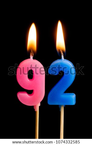 Burning candles in the form of 92 ninety two (numbers, dates) for cake isolated on black background. The concept of celebrating a birthday, anniversary, important date, holiday, table setting