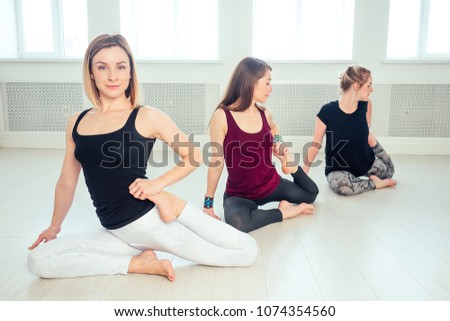 happy group of people of three women practicing yoga in the stud