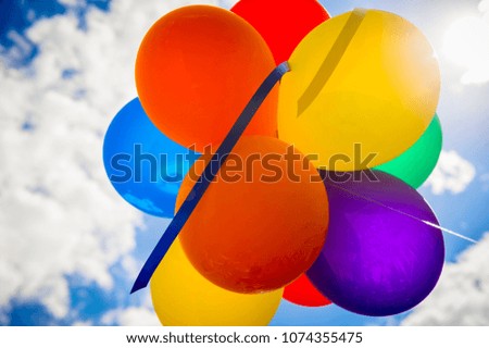 Bright abstract background of a bunch of rainbow colored balloons against sunny sky celebrating gay pride