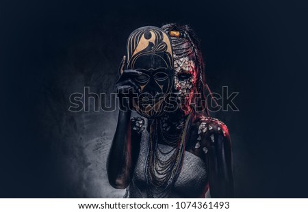 Close-up portrait of a witch from the indigenous African tribe, wearing traditional costume. Make-up concept. Royalty-Free Stock Photo #1074361493