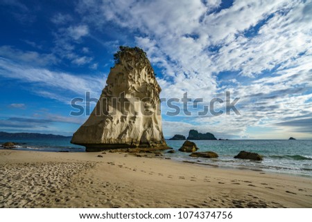 sand and the mighty sandstone rock monolith in the water of cathedral cove,coromandel, new zealand