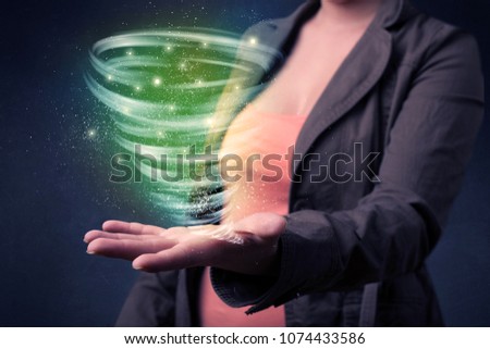 Bright green tornado in the hands of a young casual businesswoman 