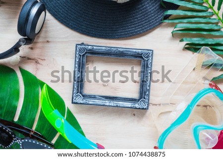 summer flat lay of copy space with sunglasses, vintage picture frame and snorkel on wood background texture, summer colorful concept