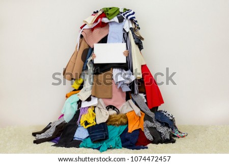 Empty copy space on the board with pile of messed up cloth on the background Royalty-Free Stock Photo #1074472457