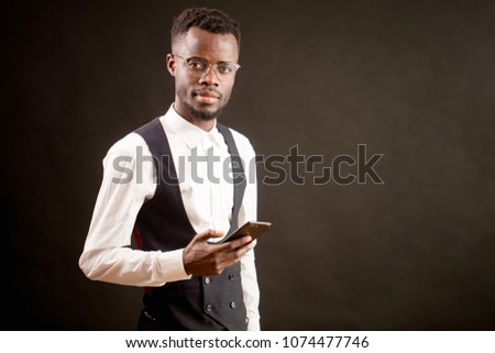 close up photo of African manager of hotel cafe standing with mobile phone.