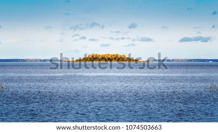 Island in the middle of the lake. Sunny autumn landscape. Beauty concept of the countryside.
