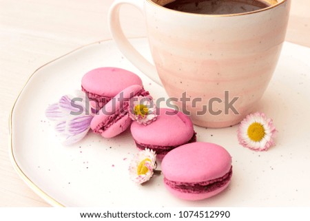Cute romantic composition with pretty cup of hot tasty coffee on white plate with delicious french dessert, floral decor. Dreaming concept. Lovely card for good morning theme