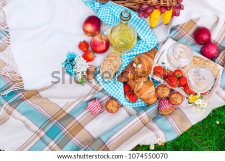 picnic basket and food. A bottle of wine and two glasses. Romanica. Green meadow with flowers. Spring in the Netherlands. Holidays. View from above
