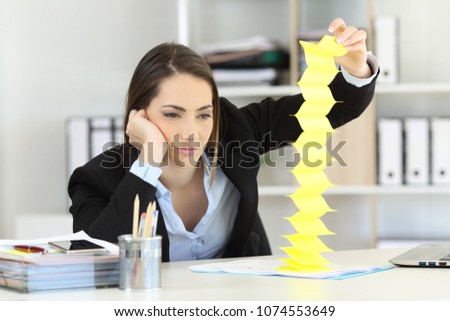 Bored executive wasting time playing with reminders at office Royalty-Free Stock Photo #1074553649