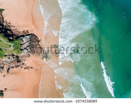 Aerial view of people surfing on a beach in Asturias, northern Spain