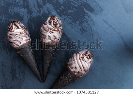 Double Chocolate Ice Creams with Black Waffle Cones on Dark Background