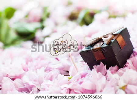 Box. Happy birthday table. Wooden leters. Black box with brown bow. Branch of sakura with flowers and leaves. Cherry blossom , pink sakura flower isolated in white background.