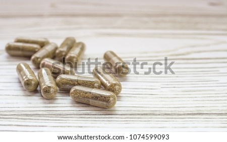 Group of clear CBD Cannabidiol capsules on bright wooden backdrop Royalty-Free Stock Photo #1074599093