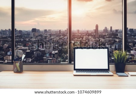 Laptop on table in office room on window city background, for graphics display montage. Take your screen to put on advertising.