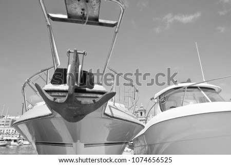 Yachts docked at the port of Malta on the background of old city. Black and white picture
