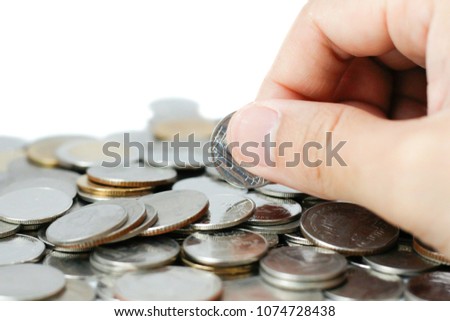 Using fingers to catching one coin from pile of coins on white background. Save money and use it for investment for your future.