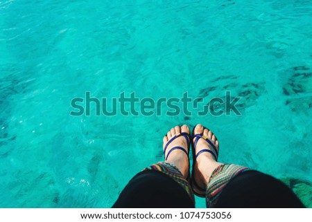 woman's feet against sea surface, relaxing concept