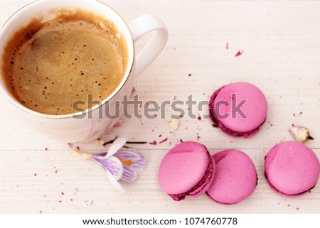 Very cute and lovely composition with cup of fresh hot coffee and some sweet french cakes on white wooden background. Overhead view. Concept for romantic "good morning" theme