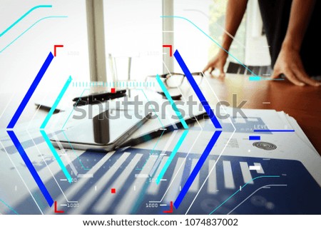 Concept of focus on target with digital diagram.business documents on office table with smart phone and digital tablet and man working in the background