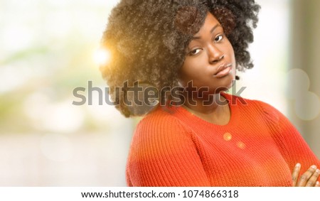 Beautiful african woman with crossed arms confident and happy with a big natural smile laughing, outdoor