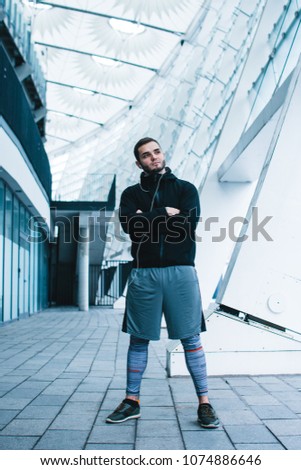 Confidant and healthy. Full length of young man in sportswear standing against industrial city view