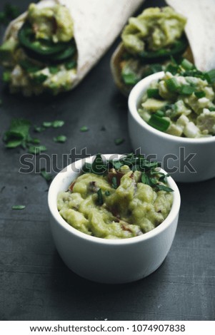 Egg salad and guacamole sauce on grey background, flour tortilla wraps