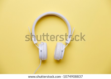 White headphones on empty yellow background