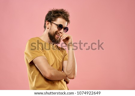  man shaggy with glasses laughing on a pink background                              
