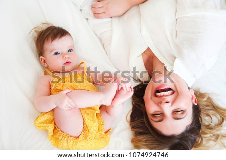 Young woman in the morning with baby girl top view. Happy family concept