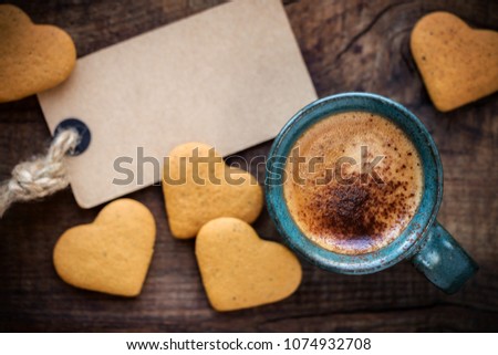 Good morning concept with cup of espresso coffee, heart shape cookies and an empty tag on rustic wooden table