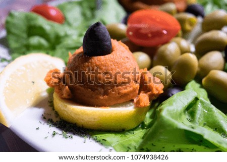 Fish beer snack served at the traditional fish restaurant of Serbia - green and black olives, fish caviar, white feta cheese and fresh vegetables