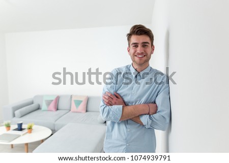 Young businessman posing in blue shirt and smiling