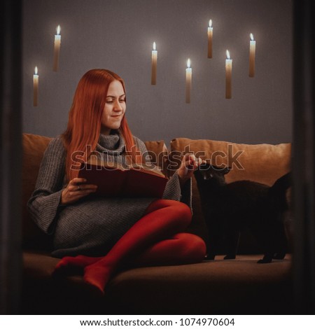 Reading is magical. Girl reading a book with candles flying around