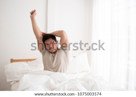 asian man wake up in the morning in modern apartment