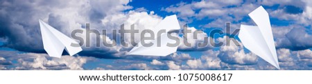 White paper airplane in a blue sky with clouds. The message symbol in the messenger.