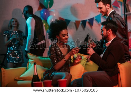 Men and women celebrating with drinks at home party