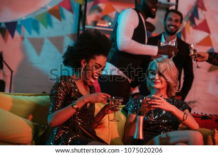 Young people celebrating with drinks in decorated room