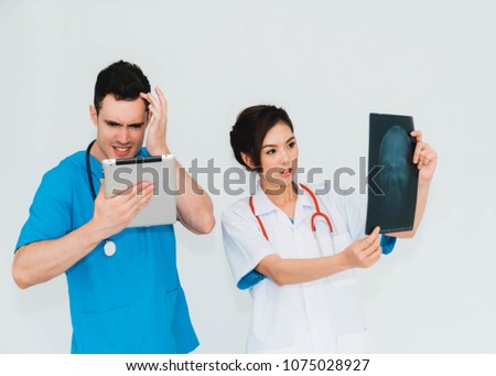 Couple doctors discussing and looking x-ray in a clinic or hospital.