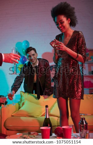 Smiling woman holding glass with drink at party