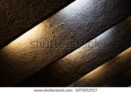 The texture of roughly plastered strips of light-lit electric bulbs