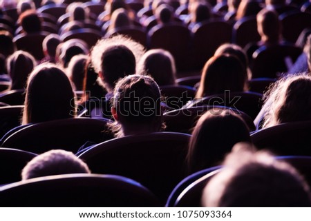 Spectators in the theater or in the cinema. Children and adults. Full house.