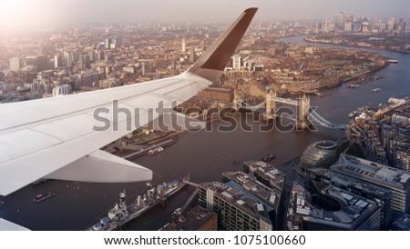 Aerial panoramic cityscape view of London and the River Thames with tower Bridge, Tower of London and City Hall with airplane wing in front, England, United Kingdom
