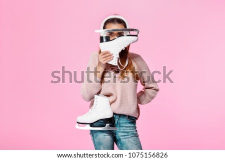 young attractive woman looking at camera through ice skates