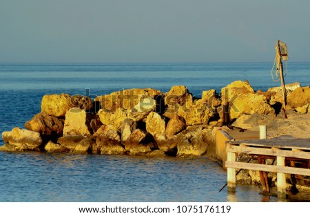Island sea view. rustic port with textured wooden pier. Near the cliffs and the sea. Stones in water
