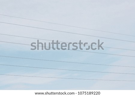 Overhead telephone cables with a blue sky and light clouds. Taken in April, in Kent, England